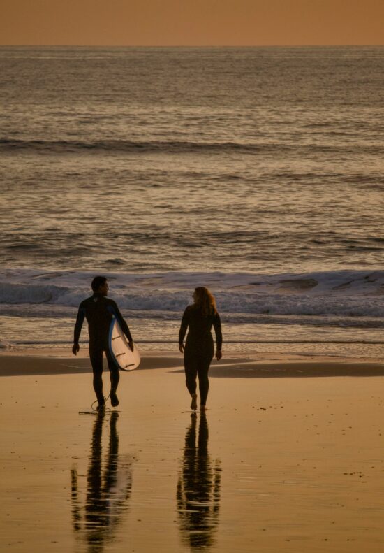 couple-surf-at-sunset